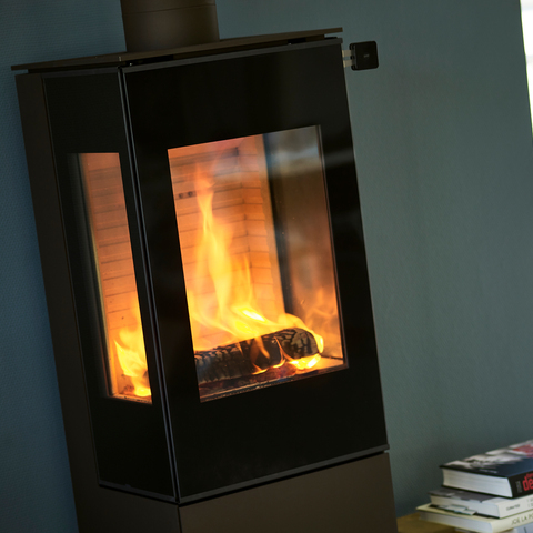 Wood stove NEXO 120 in black with glass door and two side windows with a direct view of the burning fire