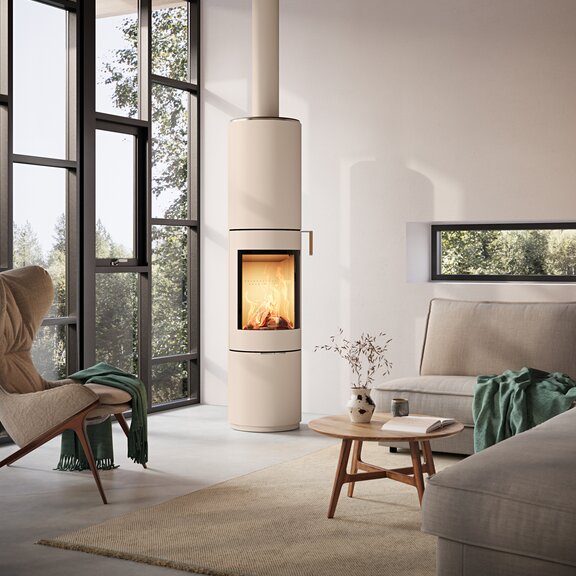 PILAR stove in sand with steel door and oak handle in a modern living room with large windows