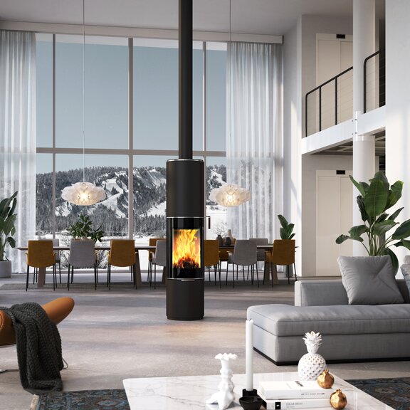 Wood stove PILAR in black with glass door as a rotating, round stove in the centre of a huge living room