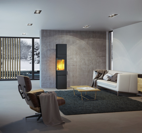 Wood stove Q-BE XL in black with steel door in a modern living room surrounded by a beautiful snowy landscape