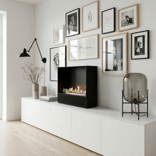 Bioethanol fireplace Milan with a black front panel, freestanding on a white sideboard in front of a picture wall