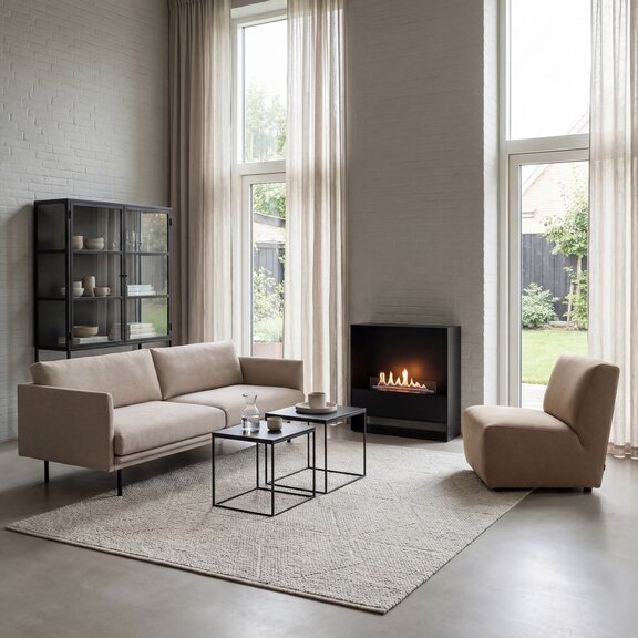 Bioethanol fireplace Milan with black front panel and base unit, freestanding in the living room in front of a white stone wall